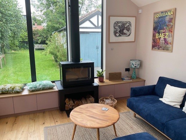 The three-sided stove seen across the garden room
