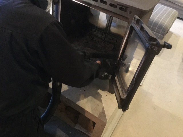 Wood burning stove being checked during servicing