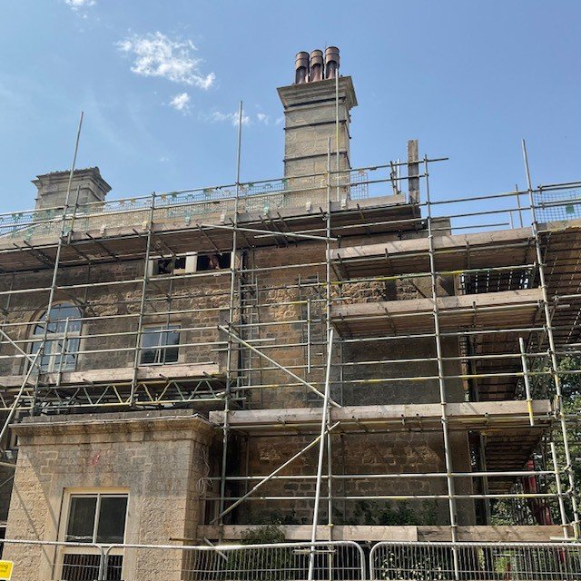 Full scaffolding erected around the tall chimney stacks at Cuckney House, Mansfield