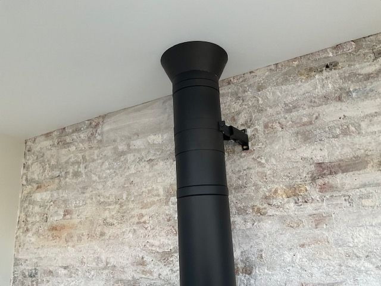 A tidy finish where the flue passes through the ceiling