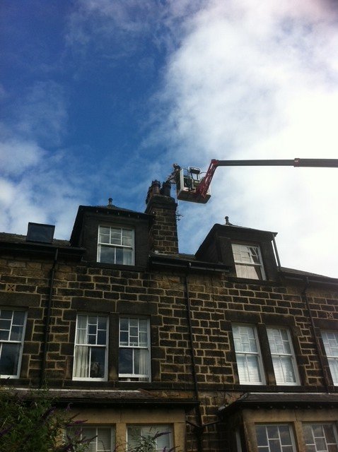 Working at height on the same Harrogate stack, with the liner fed from the pot down.
