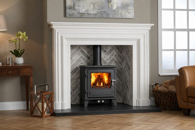Porcelain brick stove chamber in a herringbone pattern behind a wood burning stove