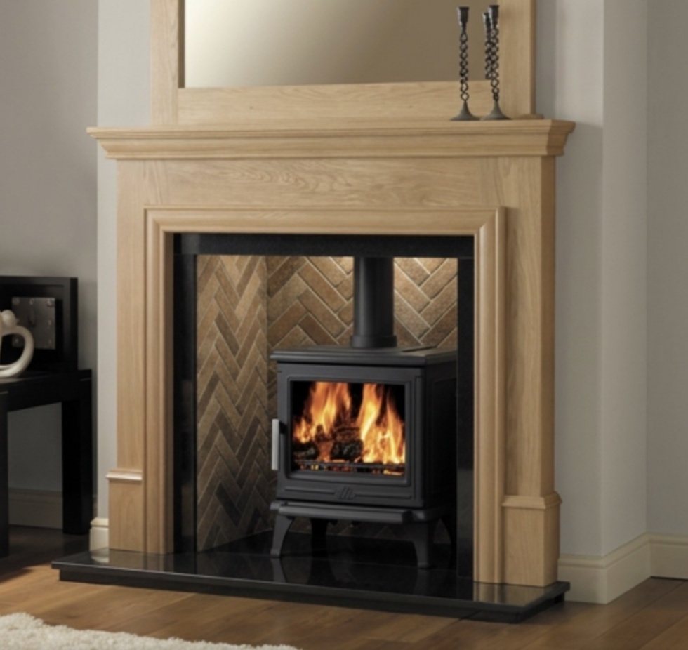 A solid oak timber fireplace surround fitted around a wood burning stove