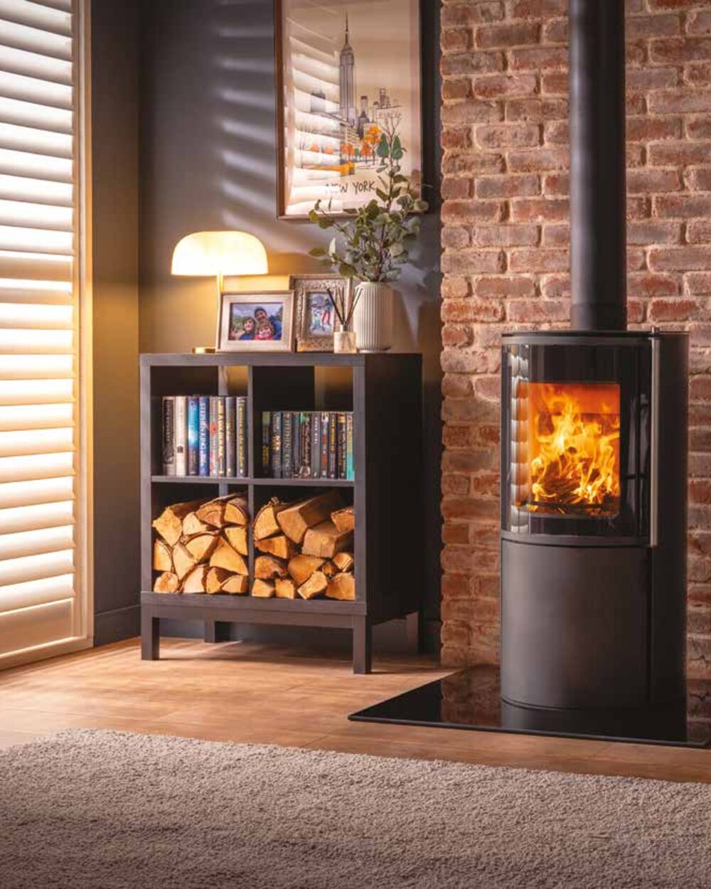 Fire FX Atlas stove beside a brick wall and log store